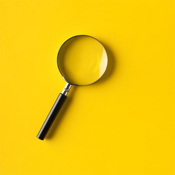 Magnifying glass on yellow background"n